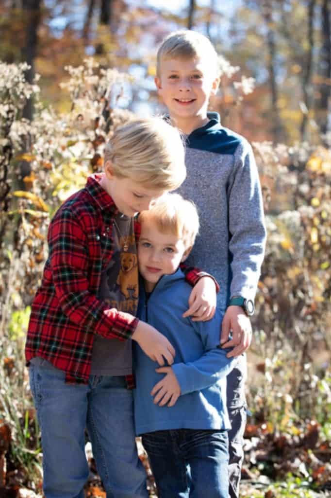 the kids in the family pose, the middle child comforts her younger brother